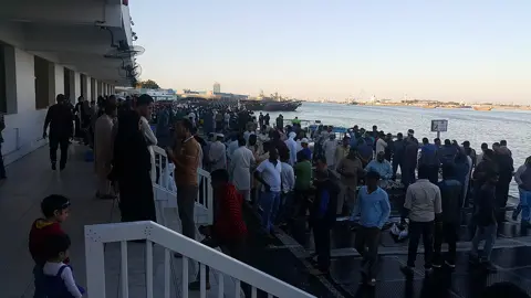 A working auction scene shows how seafood is traded at Ajman Fish Market.