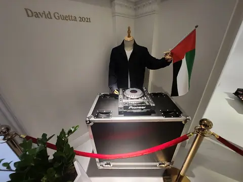 An exhibit featuring a UAE flag and a racing suit