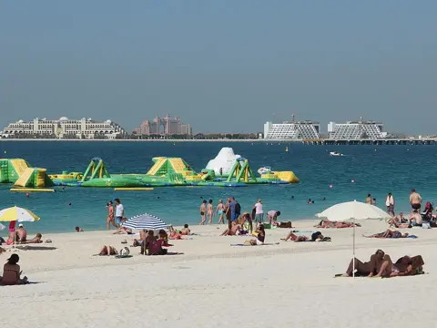 Beachgoers and floating recreation equipment off the JBR shore