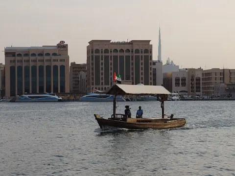 A traditional abra crosses Dubai Creek in the late afternoon, photographed in 2014