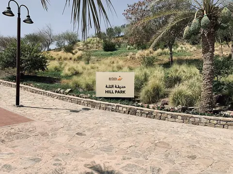 The park entrance sign beside a paved path