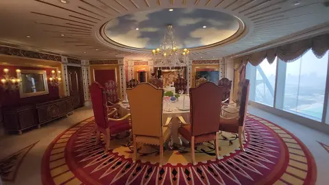 A circular interior display beneath a decorative ceiling