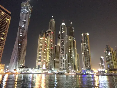 Residential towers reflected in the Marina at night