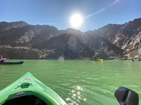 A kayak on the reservoir beneath the Hatta mountains
