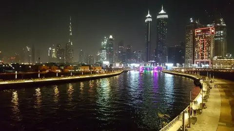 The canal promenade and city lights after dark
