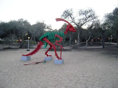 A colourful outdoor play structure among the trees