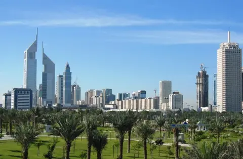 پارک کے سبز میدانوں کے آگے دبئی کا افق۔