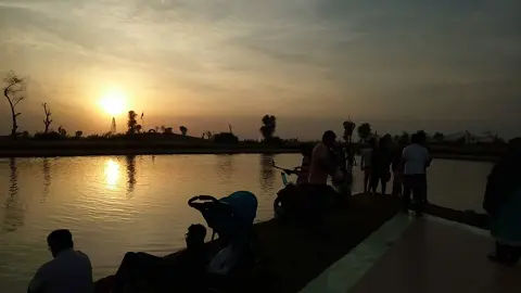 غروب کے وقت پانی کے ساتھ جمع زائرین۔