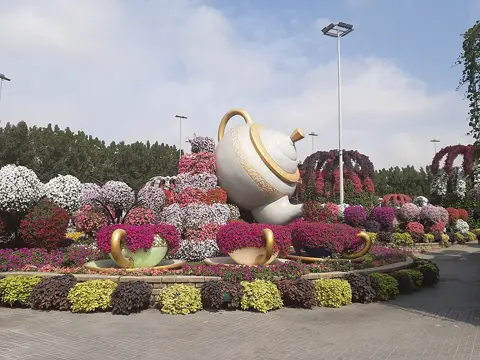 Large floral sculptures surrounded by colourful planted beds