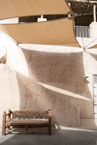 A shaded bench and traditional plastered walls