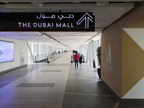 An enclosed pedestrian walkway leading towards Dubai Mall