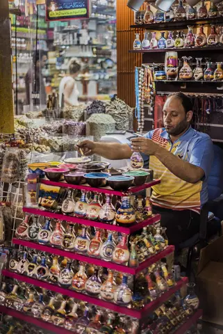 مصالحوں اور یادگاری اشیا کی نمائش کے ساتھ دکاندار۔