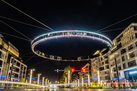 رات میں سڑک کے اوپر سٹی واک کا روشن گول نشان