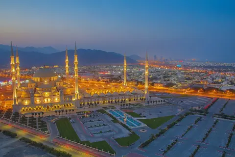 اس تعمیراتی منظر میں مسجد کے گنبد اور مینار نمایاں ہیں۔