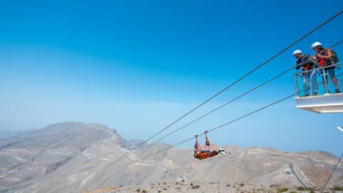 دو سوار پہاڑی وادی کے اوپر جیس فلائٹ پر سفر کرتے ہیں