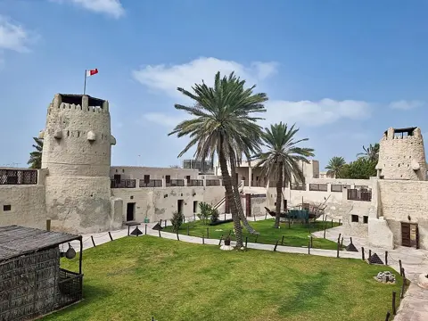 ام القیوین قلعے میں کھجوروں والا صحن اور دو نگرانی برج